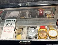 All four wristwatches in storage case