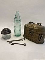 All five items together: Codd bottle, inkwell, brass cricket box, two skeleton keys
