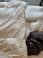 White duvet, mattress cover, and sheets displayed on bed