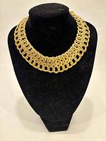 Full view of gold-tone woven collar necklace on display bust