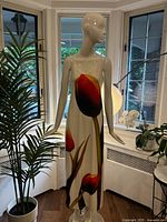 Full view of long white dress with tulip print on mannequin