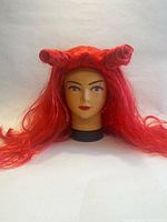 red long wig with two horn-shaped buns displayed on mannequin head