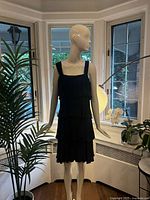 Full front view of dark blue pleated dress on mannequin