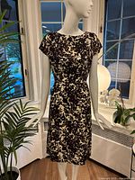 Full front view of floral sheath dress on mannequin