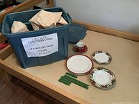 Overall lot showing storage tote, note listing contents and sample dishes