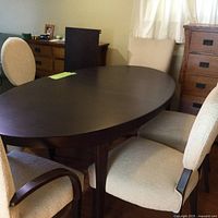 Oval wood dining table with six chairs around it