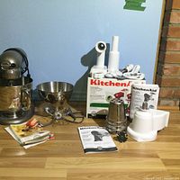 Overall view of stand mixer, bowls, attachments, grinder kit, utensils and manuals