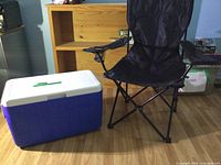 Cooler closed next to folded-out camping chair