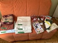 Overall lot on sofa showing folded cloth linens and packaged tablecovers