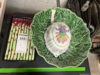 Photo showing the lettuce leaf bowl beside the rectangular asparagus serving plate with a MaxSold tag.