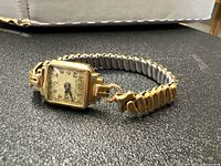 Side perspective showing rectangular gold case and expandable band