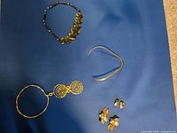 All five jewelry pieces on blue background