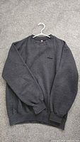 Front view of Wilson dark grey sweatshirt on hanger
