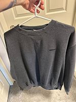 Grey Wilson crewneck long-sleeve top on hanger