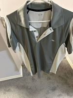 Grey and white golf polo shirt on hanger