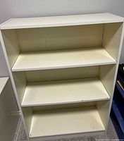 Front view showing three shelves and wear on edges