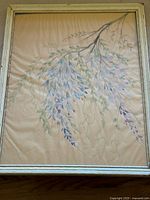 Frontal view of watercolor floral painting with detailed depiction of flower clusters and leaves, inside an antique wooden frame.