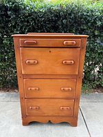 Front view of solid wood dresser with three drawers and simple wooden handles, closed.
