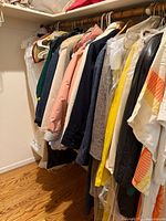 Full closet rod showing multiple vintage jackets and coats in different colors hung on hangers.