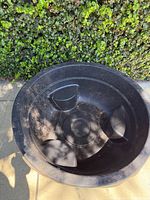 Top angled view of large black plastic pond liner showing integrated seating and raised center platform