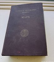 Top view of the vintage National Geographic Society Maps hardcover book showing front cover with gold embossed text and emblem.