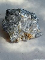 Photo of the silver ore embedded in quartz mineral specimen showing metallic and crystalline textures from one angle.