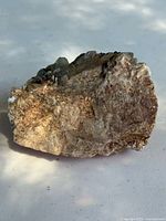 Photo of the vintage mineral specimen showing a rough feldspar matrix with visible tourmaline and quartz crystals.