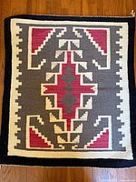 Full view of the rectangular Navajo rug laid flat, showing overall geometric pattern and color scheme.