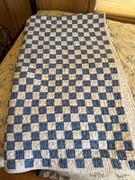 Full view of the vintage Ralph Lauren twin sized quilt laid out on a bed showing the checkered pattern in blue and white squares.
