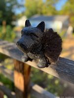 Close-up of Scottie dog boot scraper figurine showing detailed dog face and bristle body from the front.