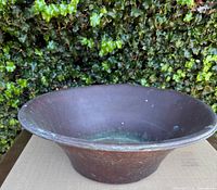 Front angle view of the vintage Smith & Hawkin copper basin showing the basin's wide rim, patina, and oxidation spots.