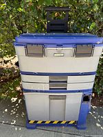 Closed view of blue and gray vintage stacking toolbox with multiple compartments and a handle