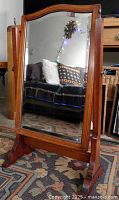Full view of mirror on stand showing wood frame, beveled glass and swivel side posts