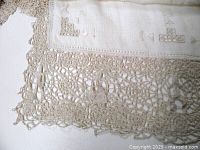 Close-up of lace border with figural motif on linen