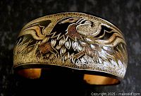 Front view of copper cuff showing engraved eagle and foliage design