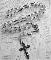 Full view of sterling and crystal rosary laid out to show length and bead style
