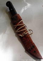 Knife in full view inside tooled leather sheath