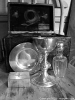 full kit with case open, chalice, paten, bottle, pyx visible