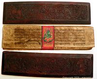 Full view of both carved covers and manuscript pages with painted deity