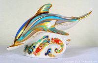 Left profile of patterned porcelain dolphin on integral base