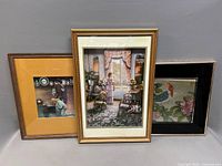 All three framed lithographs standing together