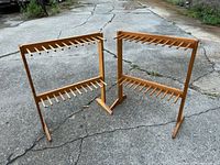 Both wooden racks standing on pavement showing overall structure and peg arrangement