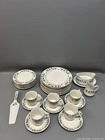 All dinnerware pieces arranged, showing holly pattern