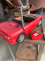 Overall view of red Ferrari Barbie RC car with controller