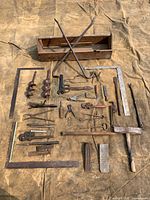 All tools laid out showing full lot, including augers, squares, pliers, tool box
