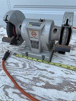 Front view of Black & Decker bench grinder with measuring tape for scale