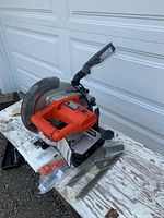 Overall view of saw showing motor housing, base, blade, dust bag, hardware pack and manual