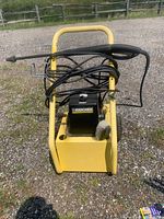 Front view of pressure washer showing frame, motor housing, spray gun and hose