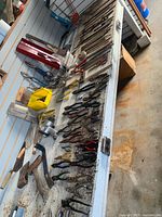 Workbench view with tongs, hammers, shears, tool cases, nail pouch