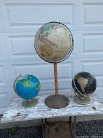 Group shot of the three globes on bench